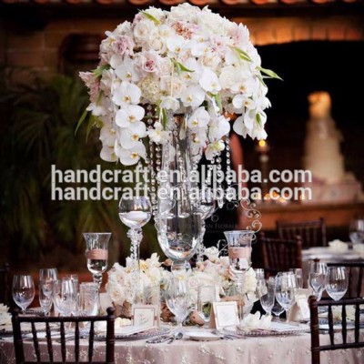 Centerpiece flower arrangement with white orchids cascading over the side dripping crystal beads and roses